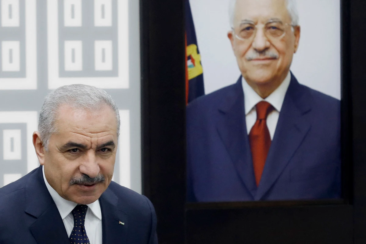 Palestinian PM Mohammad Shtayyeh stands next to a portrait of the Palestinian Authority’s President Mahmud Abbas during cabinet meeting in Ramallah on Feb. 26, 2024. (AFP)