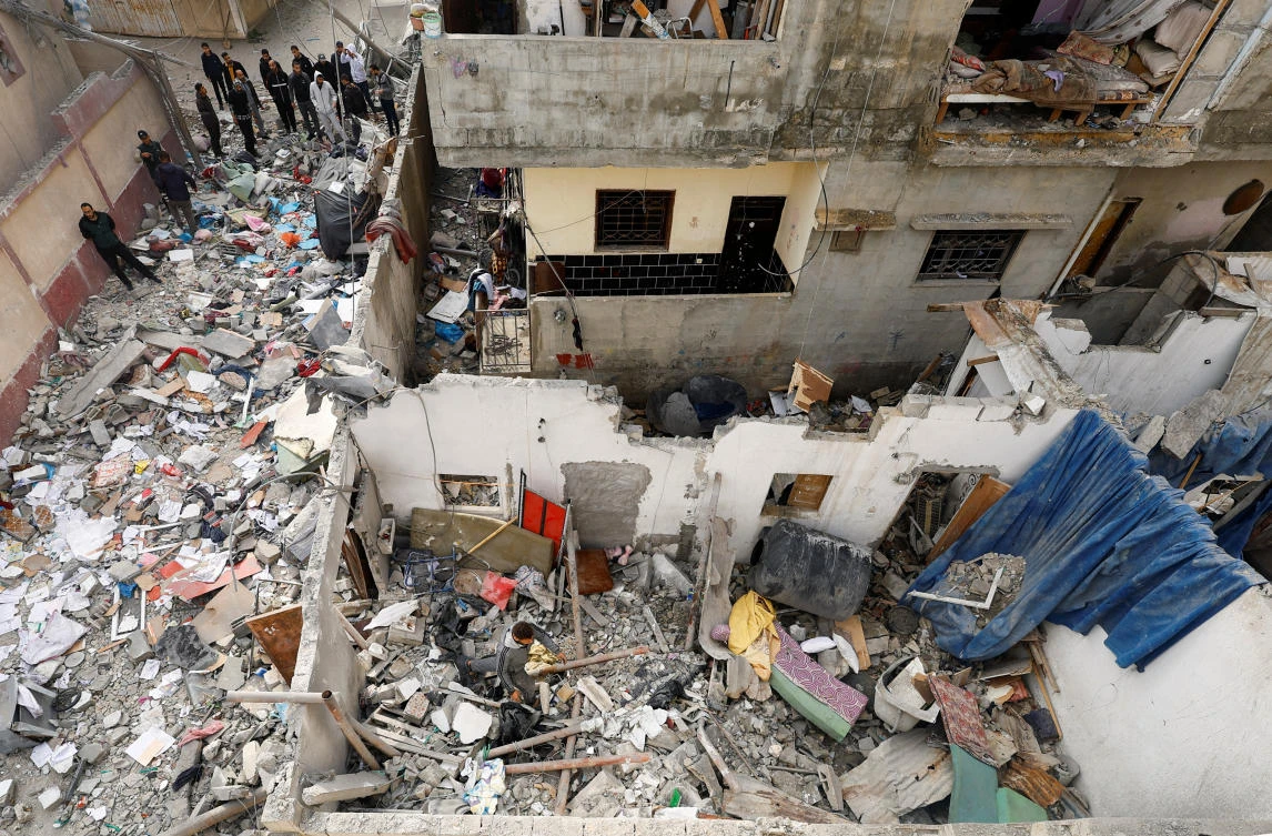 Above, Palestinians inspect the site of an Israeli strike on a house in Rafah in the southern Gaza Strip on Feb. 27, 2024. (Reuters)