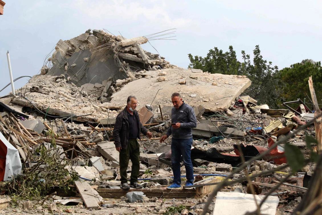 Men check the site of an Israeli air strike that targeted a house in the southern Lebanese village of Jibshit on Feb. 27, 2024. (AFP)