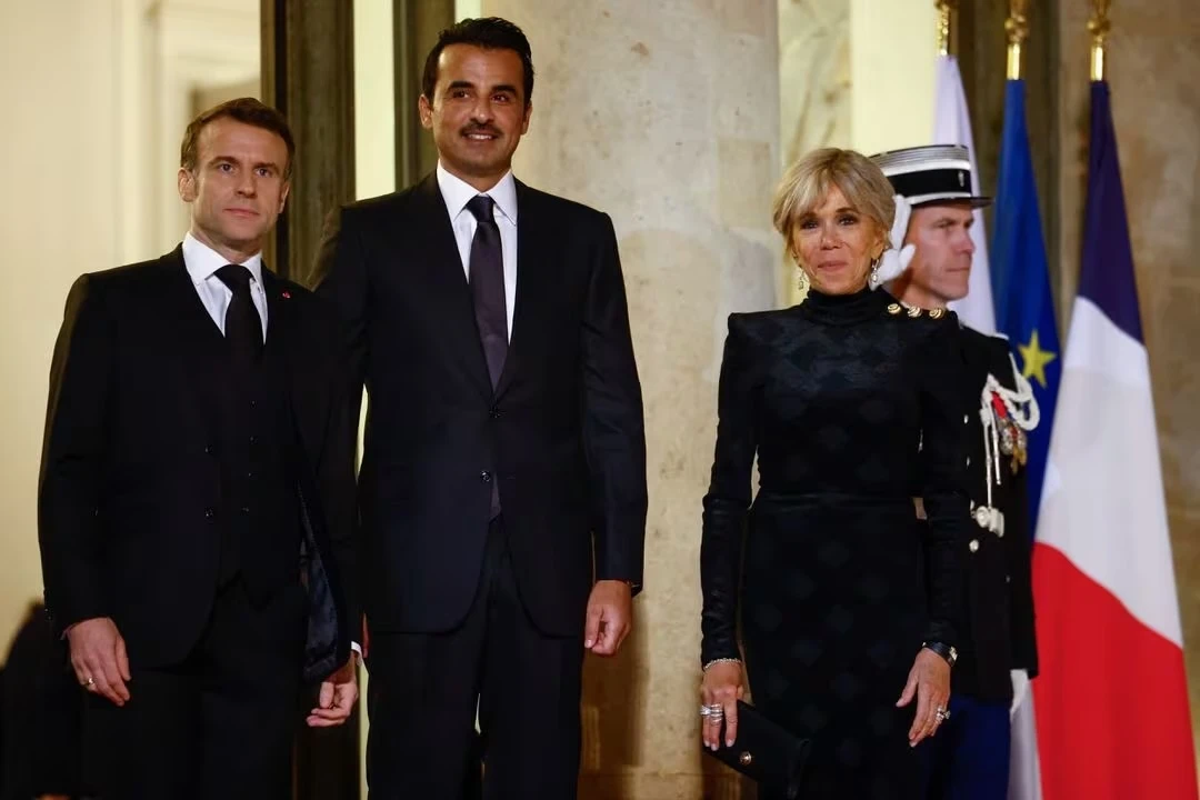 Qatar's Emir Sheikh Tamim bin Hamad Al Thani poses alongside French President Emmanuel Macron and his wife Brigitte Macron before a state dinner at the Elysee Palace as part of a two day state visit in Paris, France, February 27, 2024. REUTERS