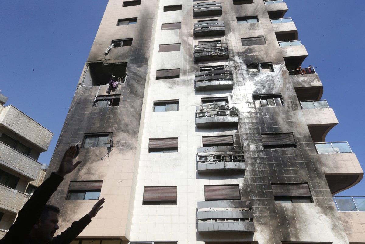 A man reacts ouside a buildling reportedly targeted by Israeli air strikes in the Kafr Sousa district of the Syrian capital Damascus on February 21, 2024 (AFP)