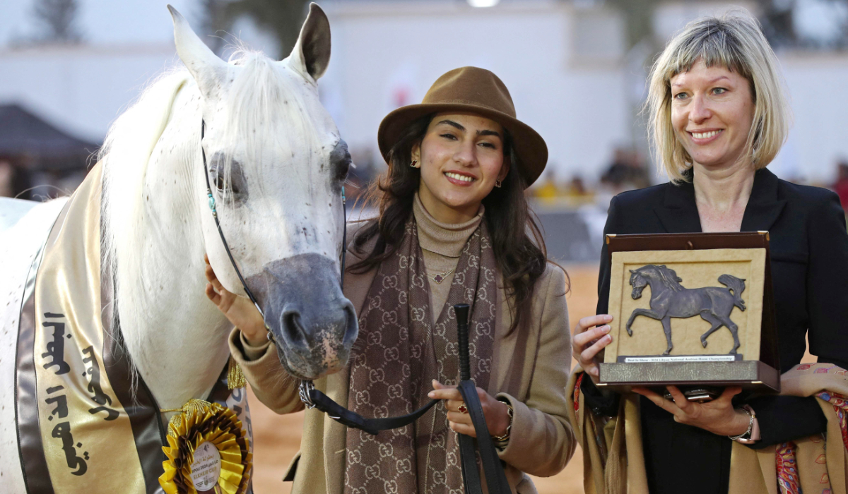 Participants pose with their Best in Show trophy after taking part in the National Championship of Libyan Arabian Horse (Elkheir Cup) on the outskirts of Tripoli on March 3, 2024. (AFP)