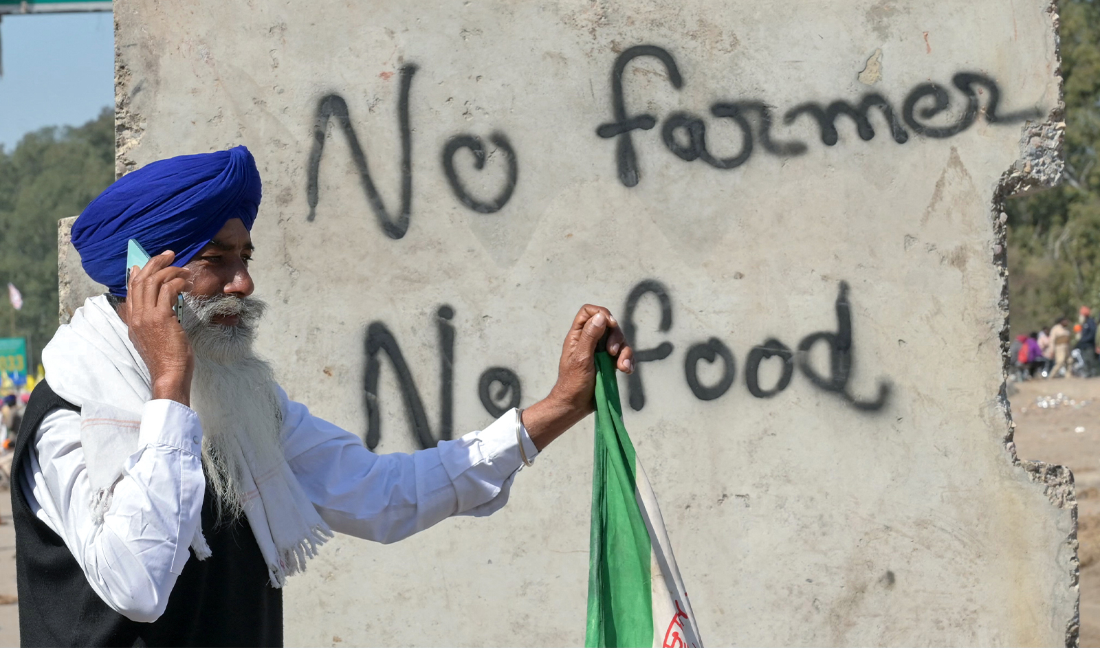 A farmer talks on his mobile phone during an ongoing protest to demand minimum crop prices, near the Punjab-Haryana state border at Shambhu in Patiala district on February 22, 2024. (AFP)