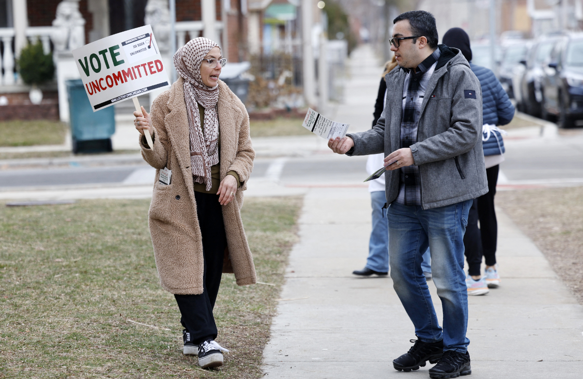 Aruba Obeid (L) asks people to vote uncommitted, instead of for US President Joe Biden, outside of Maples Elementary School in Dearborn during the Michigan presidential primary election on February 27, 2024. (AFP)