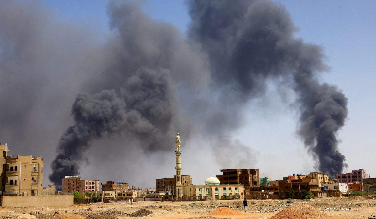 A man walks while smoke rises above buildings after aerial bombardment, during clashes between the paramilitary Rapid Support Forces and the army in Khartoum North, Sudan, May 1, 2023. (REUTERS)