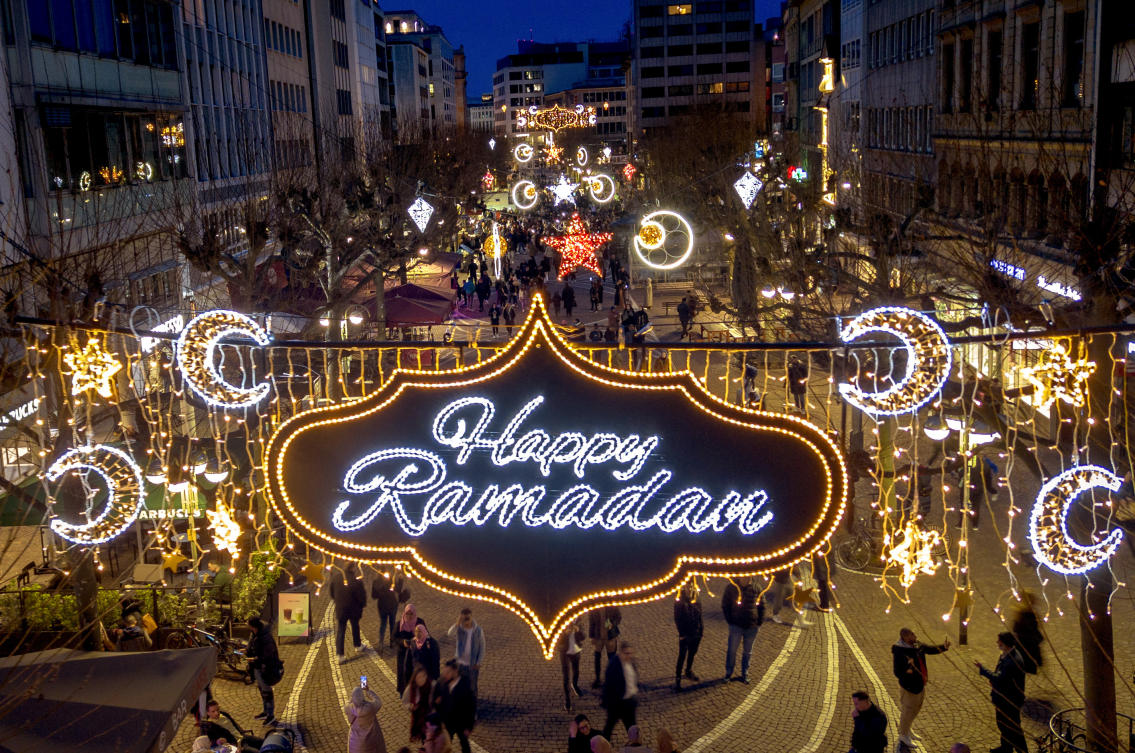 A “Happy Ramadan” sign is illuminated on the occasion of the beginning of the holy month of Ramadan, when observant Muslims fast from dawn to dusk, in a pedestrian zone in Frankfurt, Germany, Sunday, March 10, 2024. (AP)