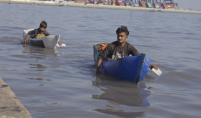 The photo taken on March 6, 2024, shows young fishermen aboard their plastic boats to catch fish in Karachi, Pakistan. (AN Photo)