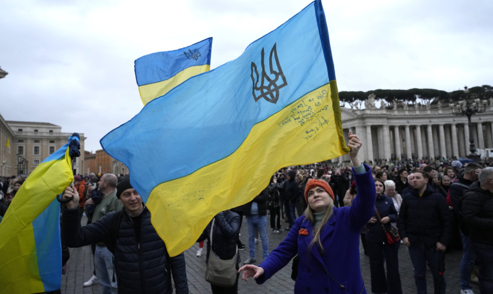 People waves Ukrainian flags before Pope Francis Angelus noon prayer from the window of his studio overlooking St.Peter's Square, at the Vatican, Sunday, March 10, 2024. (AP)