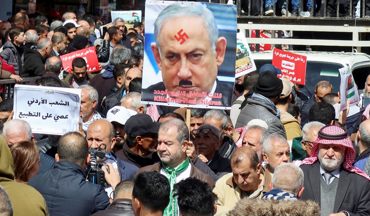 Demonstrators carry banners, including a poster of Israeli Prime Minister Benjamin Netanyahu with Nazi symbols, during a protest in support of Palestinians in Gaza, amid the ongoing conflict between Israel and the Palestinian Islamist group Hamas, in Amman, Jordan March 8, 2024. (REUTERS)