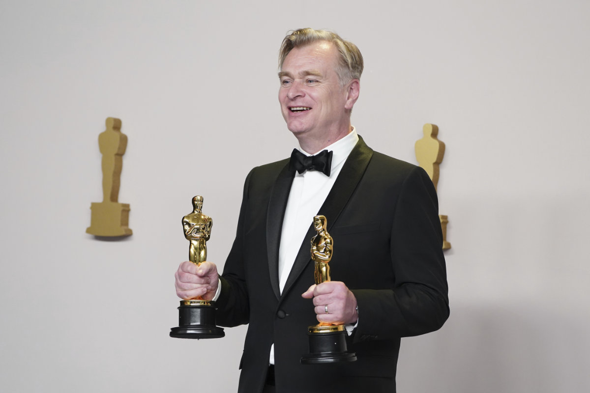 Christopher Nolan poses in the press room with the awards for best director and best picture for "Oppenheimer" at the Oscars on March 10, 2024. (Invision/AP)