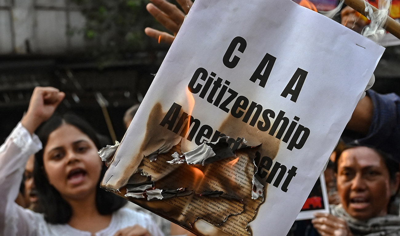 Activists shout slogans as they burn a copy of the Citizenship Amendment Act (CAA) bill during a protest rally in Kolkata on March 12, 2024. (AFP/File)