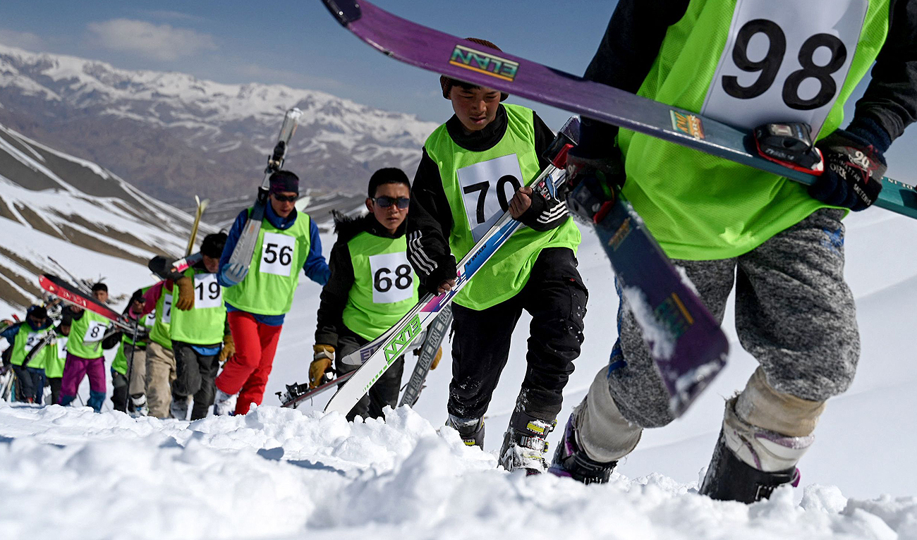 Afghan skiers walk uphill to compete in a ski race on the outskirts of Bamiyan province on March 8, 2024. (AFP)