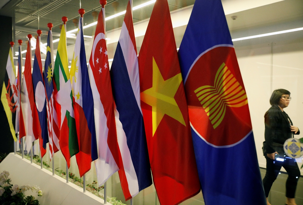In this file photo, a woman passes ASEAN Summit flags at Suntec Convention Centre in Singapore on Nov. 11, 2018. (Reuters)