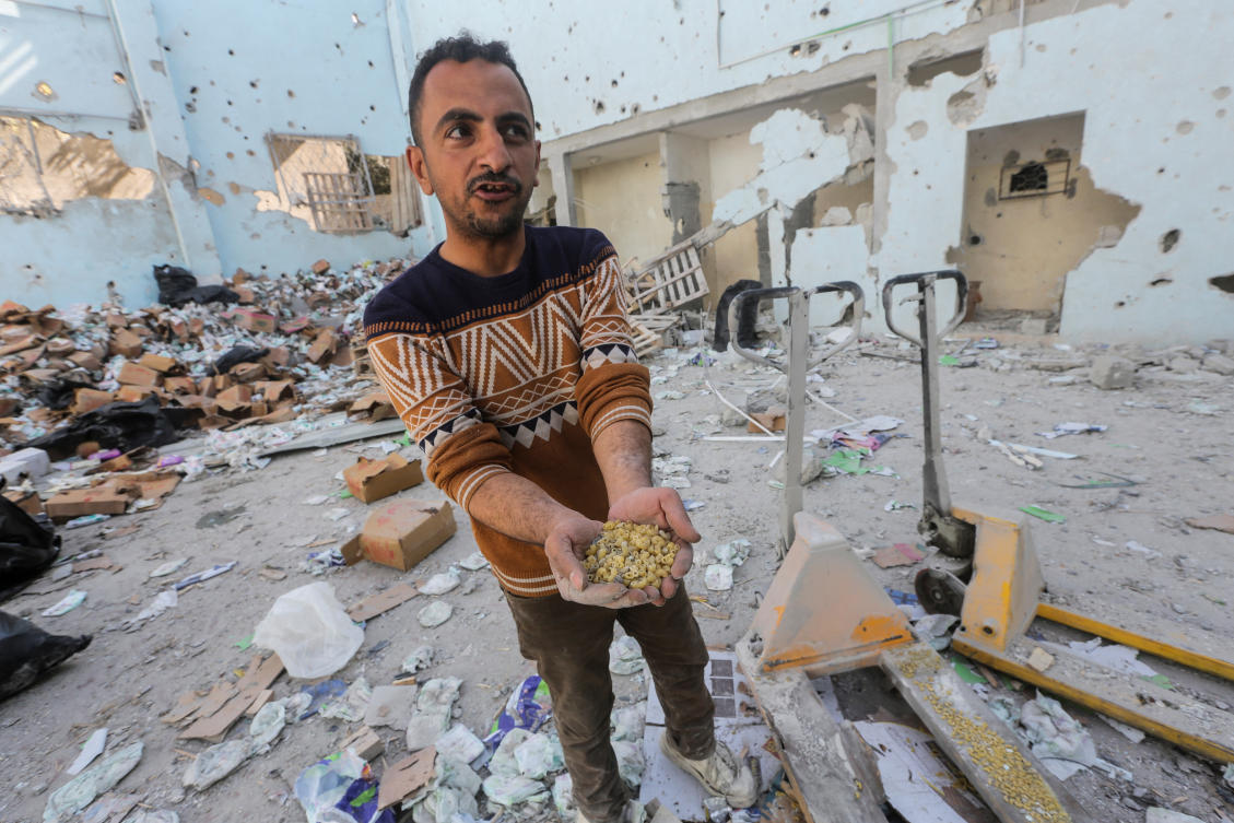 A Palestinian holds pasta pieces at the site of an Israeli strike on an aid warehouse in Al-Nuseirat refugee camp in the central Gaza Strip on Mar. 14, 2024. (Reuters)