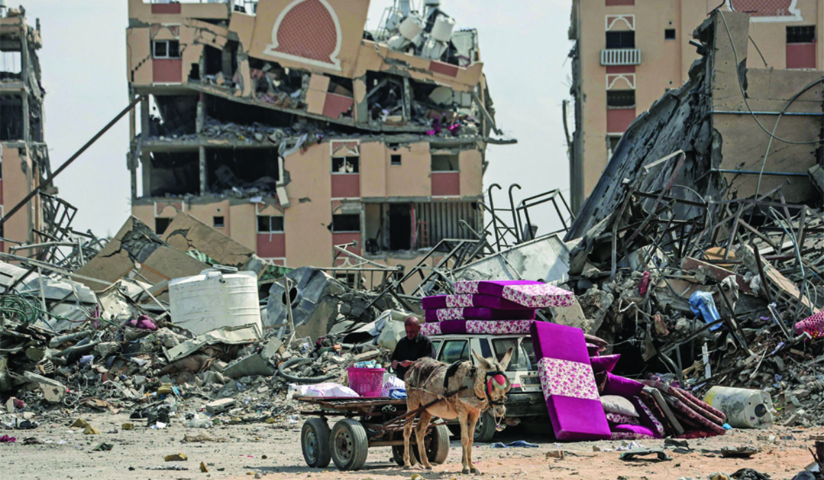 A displaced Palestinian man sits on a donkey cart amid the rubble of houses destroyed by Israeli bombardment in Hamad area, west of Khan Younis in the southern Gaza Strip, amid the ongoing conflict between Israel and Hamas. (AFP)