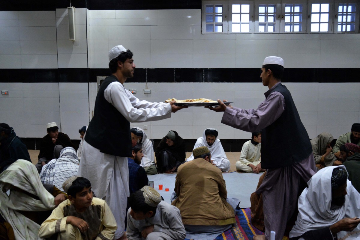Afghan Muslims distribute food in a mosque during iftar on the first day of Islamic holy month of Ramadan in Kandahar on March 11, 2024. (AFP)