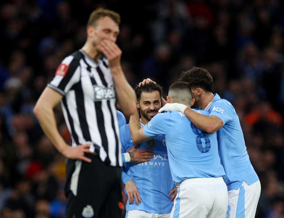 Newcastle United's Dan Burn looks dejected as Manchester City's Bernardo Silva and teammates celebrate after scoring their second goal on March 16, 2024. (Action Images via Reuters)