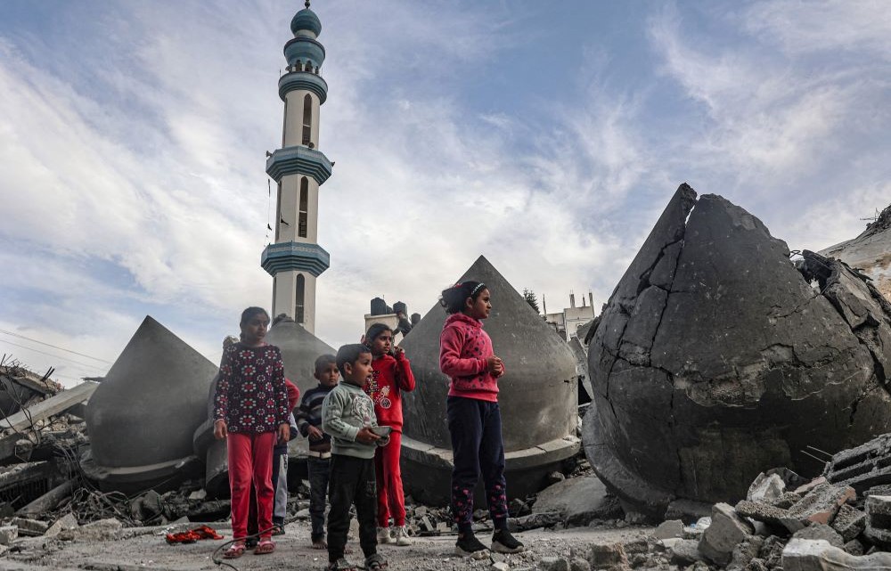 Children stand next to the rubble of Al-Faruq Mosque, that was destroyed during Israeli bombardment, in Rafah, southern Gaza Strip on March 17, 2024. (AFP)