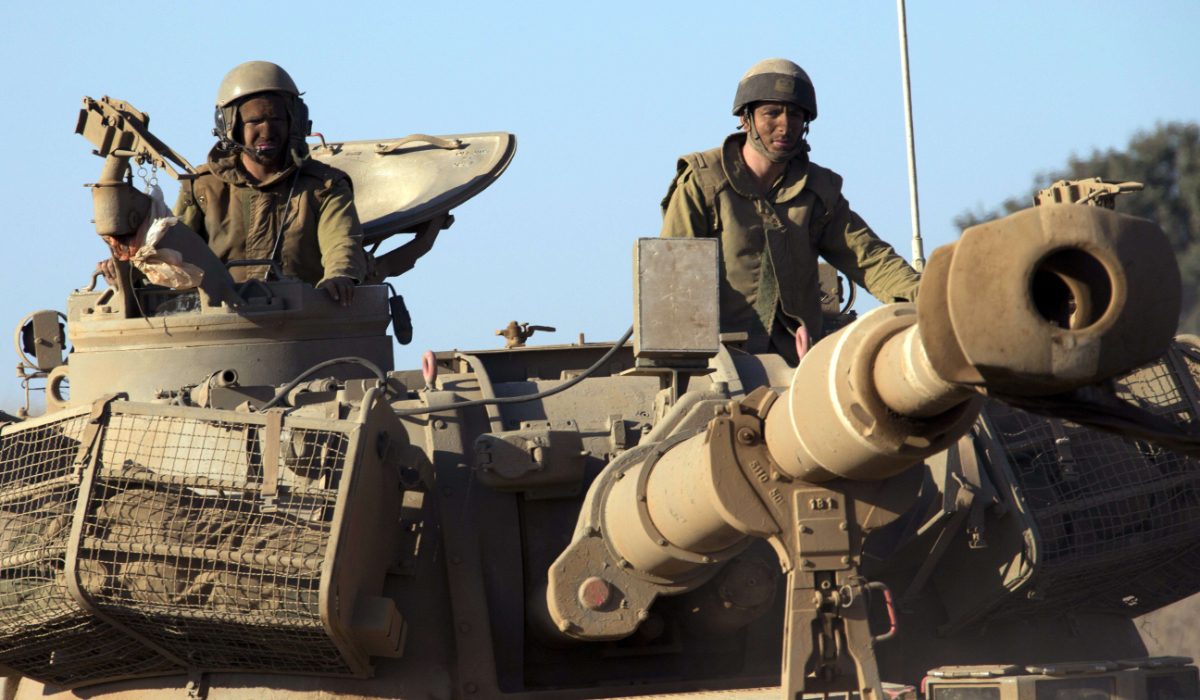 Israeli soldiers ride on top of a mobile artillery vehicle as it drives through sandy terrain during a military exercise in the Israeli-occupied Golan Heights, north of Israel. (AFP file photo)