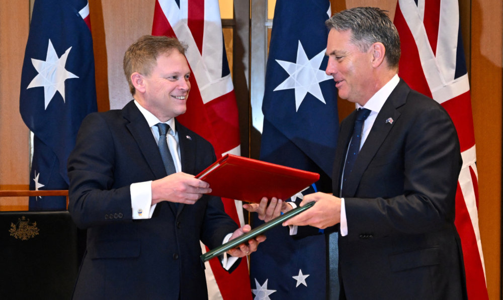 Secretary of State for Defense of the United Kingdom Grant Shapps (L) and Australian Defense Minister Richard Marles exchange Defense Treaty documents during a meeting at Parliament House in Canberra, March 21, 2024. (Reuters)