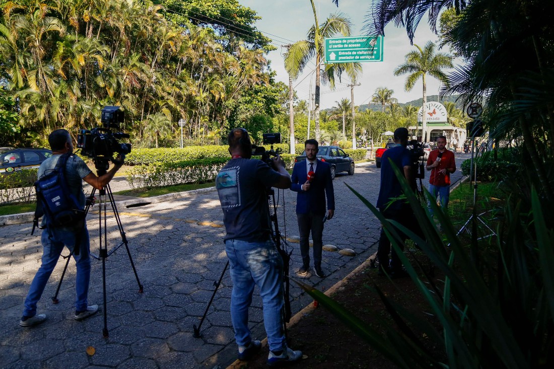 Members of the media work at the entrance of the Acapulco Condominium, the house of the Brazilian former football player Robinho, in Guaruja City, on the coast of Sao Paulo, Brazil, on March 21, 2024. (AFP)