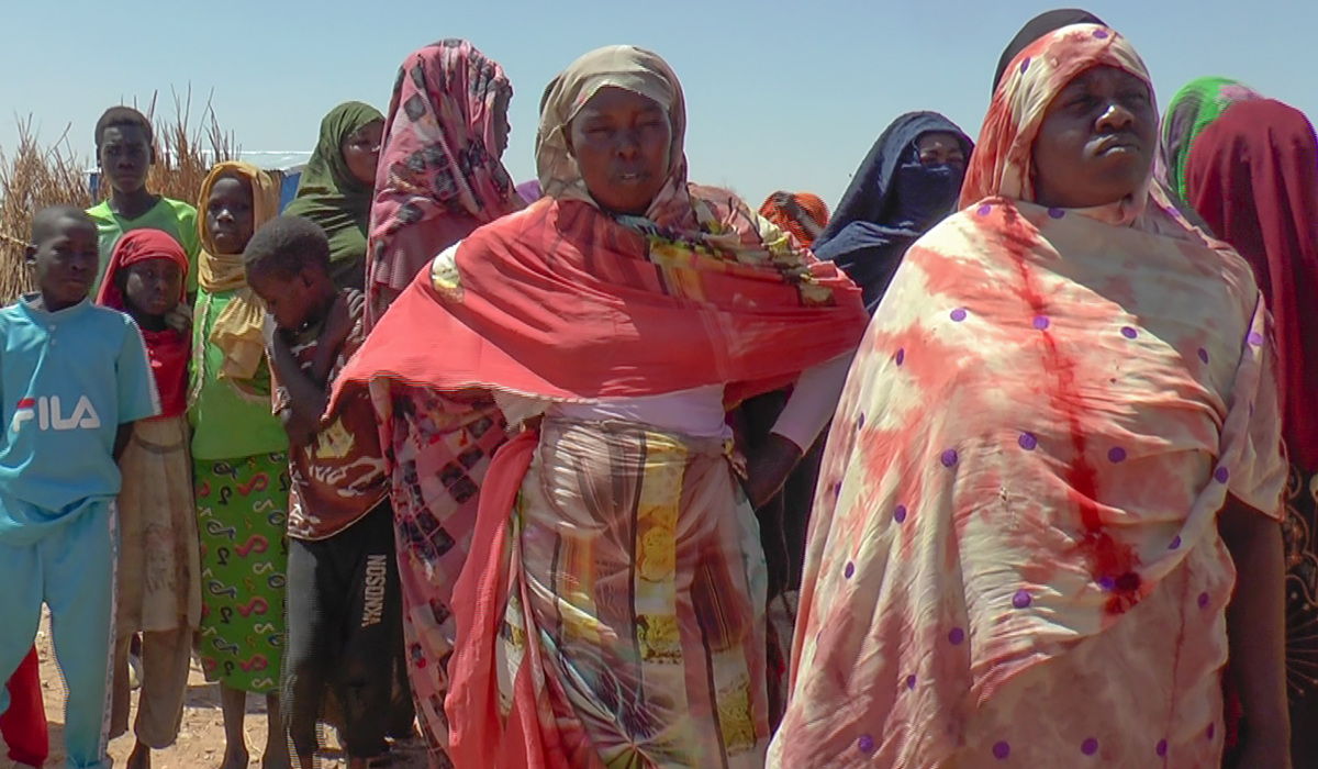 Refugees displaced by the conflict in Sudan gather to receive food staples from aid agencies at the Metche Camp in eastern Chad. (AP)