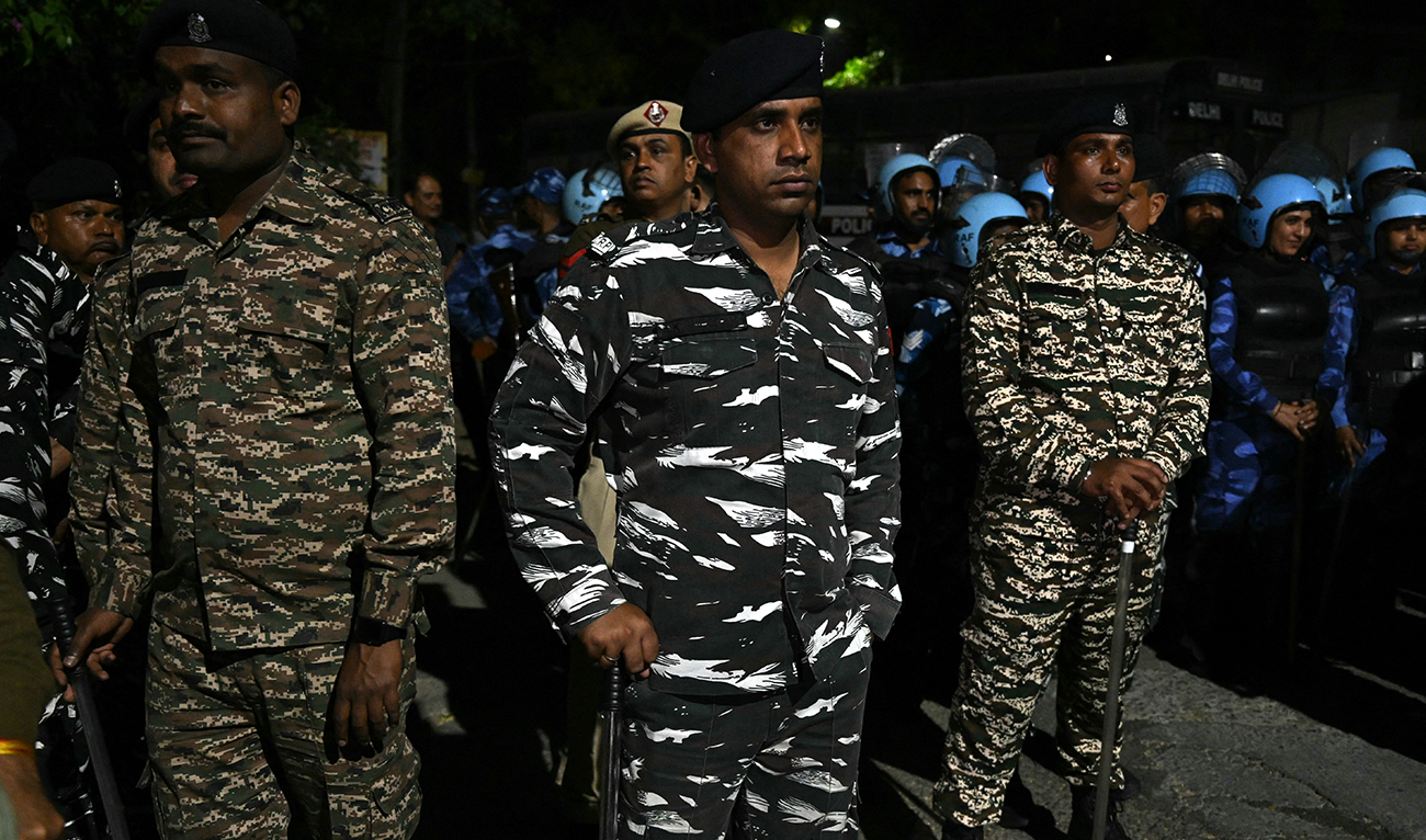 Police officers and Indian Rapid Action Force officers (background) stand guard in front of the home of Aam Aadmi Party chief and Delhi Chief Minister Arvind Kejriwal, after he was arrested in a corruption case by the Enforcement Directorate, as supporters of the Aam Aadmi Party gather, in New Delhi on March 21, 2024. (AFP)