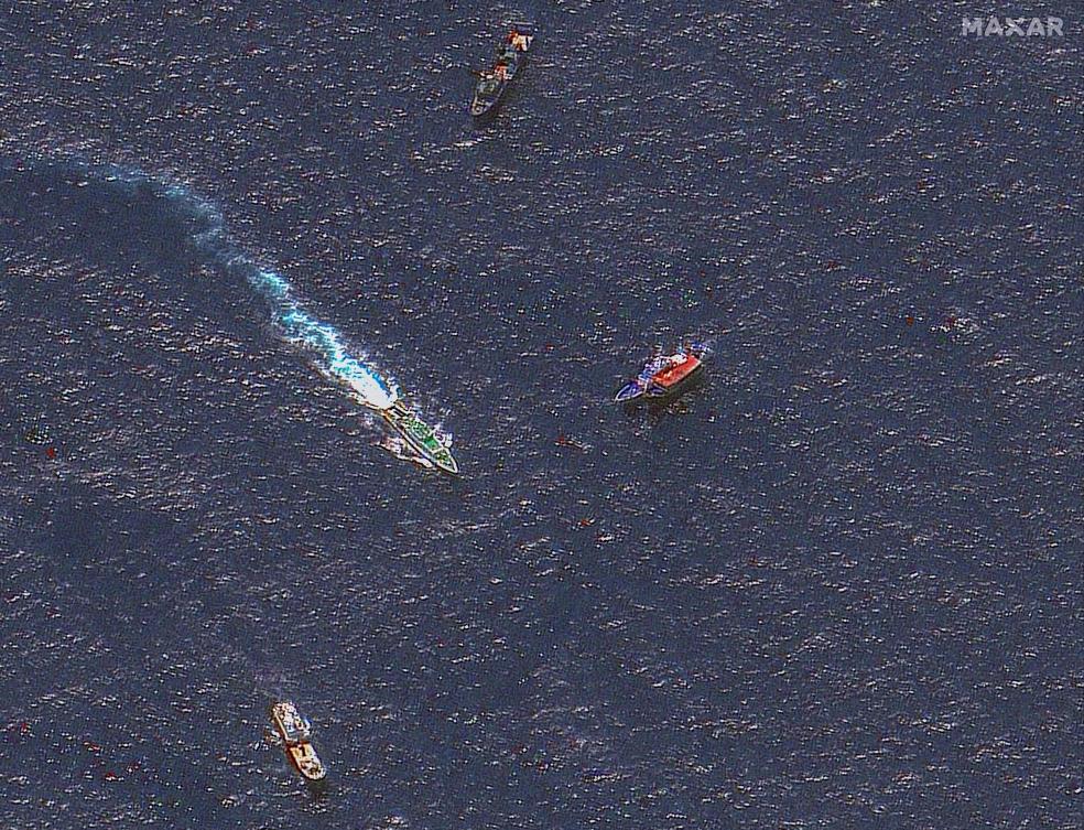 Above, a handout satellite image shows Chinese and Philippine ships in disputed waters of the South China Sea. (Maxar Technologies via AFP)