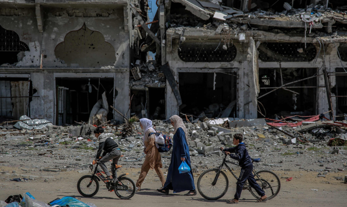 Palestinians walk next to destroyed buildings in the northern Gaza Strip on March 21, 2024, amid the ongoing violence between Israel and the Palestinian Hamas movement. (AFP)