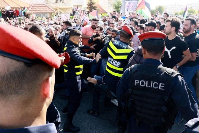 Protesters scuffle with Jordanian police near the Israeli Embassy in Amman on October 18, 2023. (File/AFP)