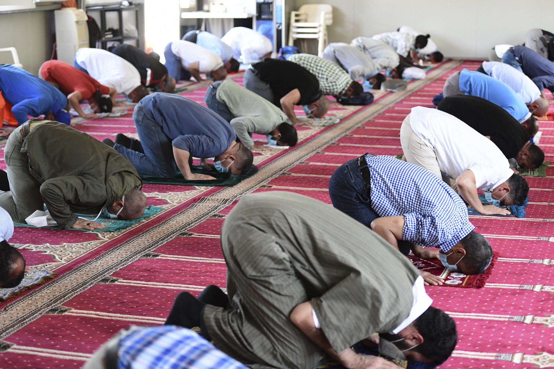 Muslims wearing protective face masks observe social distancing amid the COVID-19 coronavirus pandemic, while they attend the Friday prayer at a mosque in Milan on June 5, 2020. (AFP)