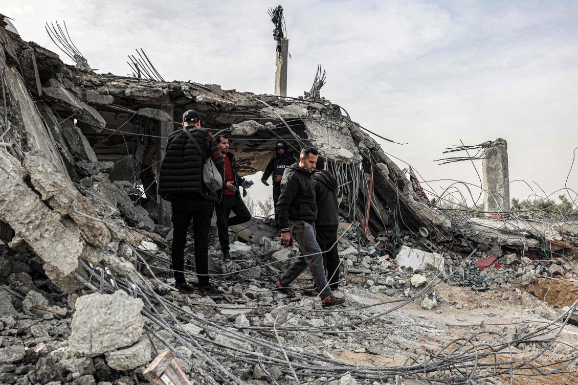 People inspect damage to a building that was hit overnight during Israeli bombardment in Rafah in the southern Gaza Strip on Mar. 26, 2024. (AFP)