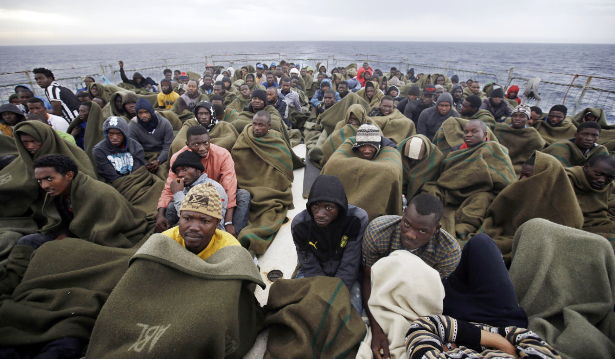 Migrants sit on the deck of a Belgian Navy vessel after they were saved in the Mediterranean Sea off the Libyan coast on June 24, 2015. (AP)