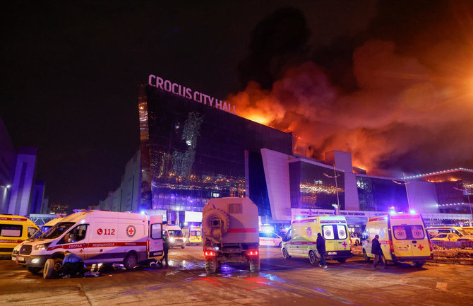 Vehicles of Russian emergency services are parked near the burning Crocus City Hall concert venue following a reported shooting incident, outside Moscow, on Mar. 22, 2024. (Reuters)