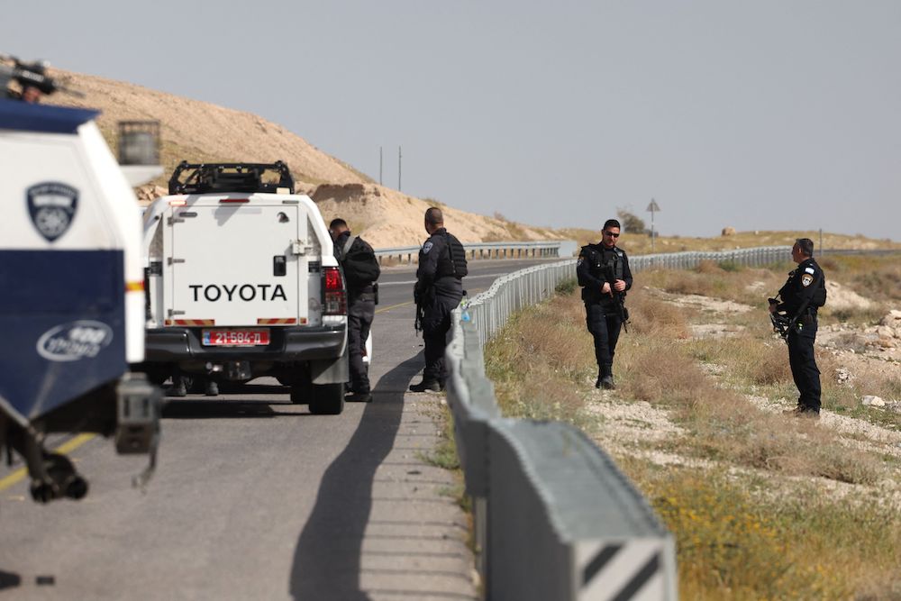 Above, Israeli security forces stand guard on a road in the occupied West Bank following a shooting attack on March 28, 2024. ( AFP)