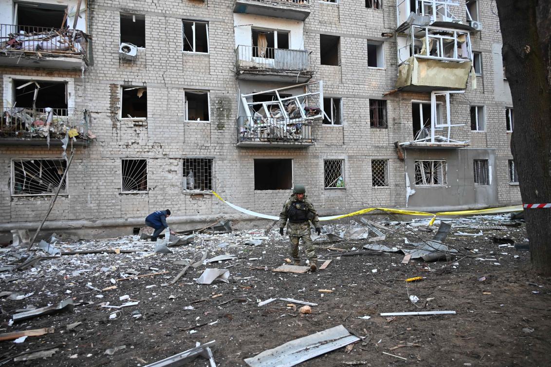 A rescuer works outside a residential building damaged as a result of Russian strikes in Kharkiv on March 27, 2024, amid Russian invasion in Ukraine. In Ukraine's second largest city Kharkiv, which has been reeling from power outages due to the strikes, officials said aerial bombing and shelling killed at least one person and injured 18 others. (Photo by SERGEY BOBOK / AFP)