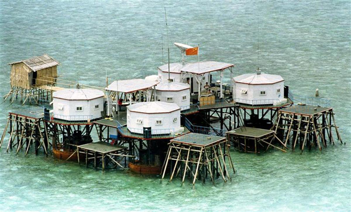 Above, a Chinese flag and a satellite dish in a structure built by China in this May 1995 file photo. China, which claims almost the entire South China Sea as its own, has accused the Philippines of encroaching on its territory. (Reuters file photo)