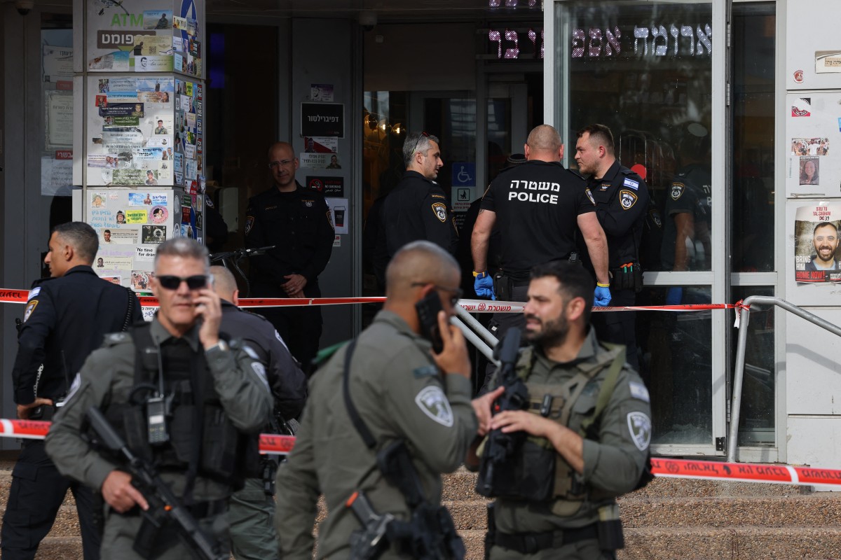 File photo of Israeli security forces and police officers gathering at the site of a reported stabbing attack at a shopping centre in Beit Kama in southern Israel (AFP)