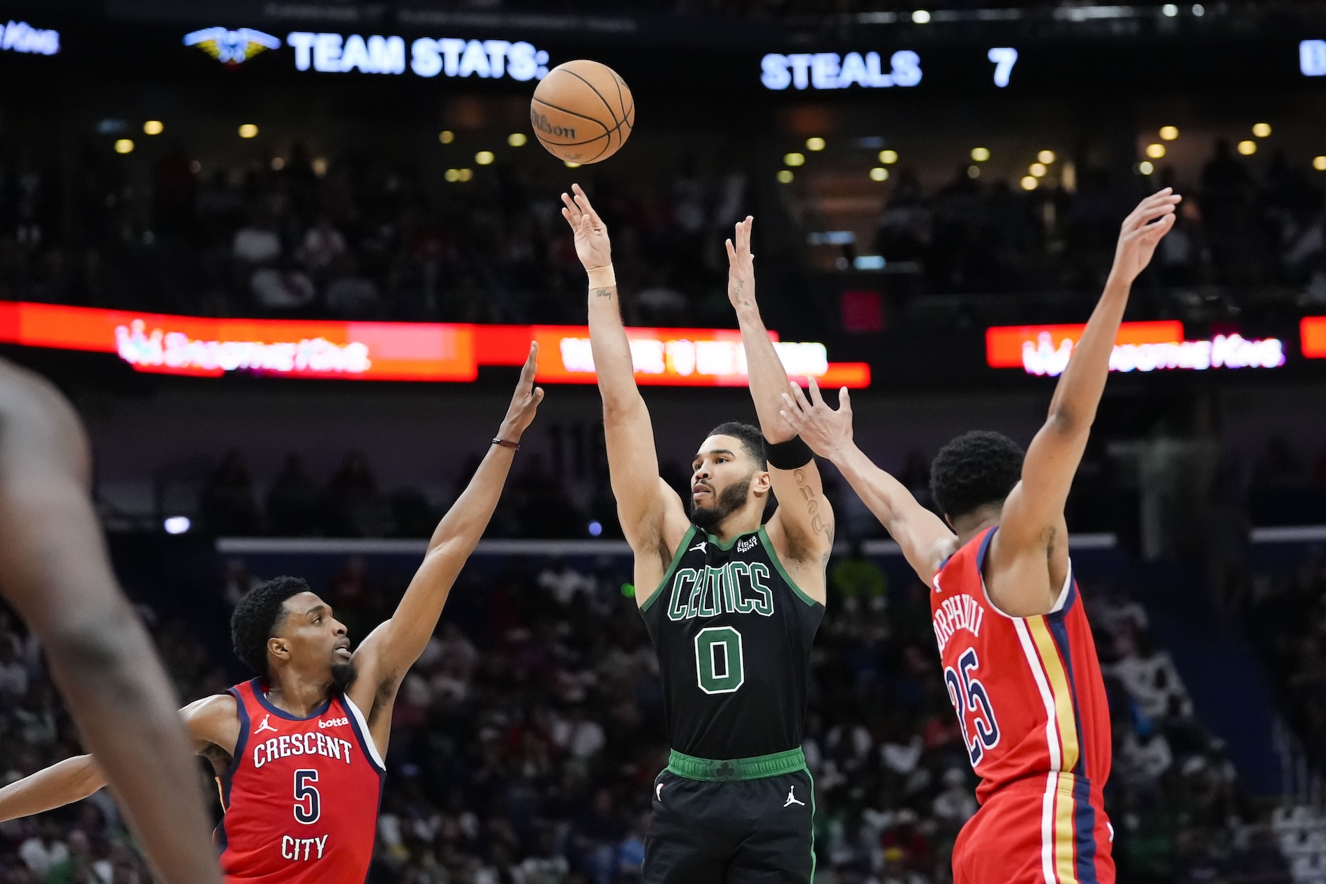 Boston Celtics forward Jayson Tatum shoots between New Orleans Pelicans forward Herbert Jones (5) and guard Trey Murphy III in the second half of an NBA basketball game in New Orleans Saturday. The Celtics won 104-92. (AP)