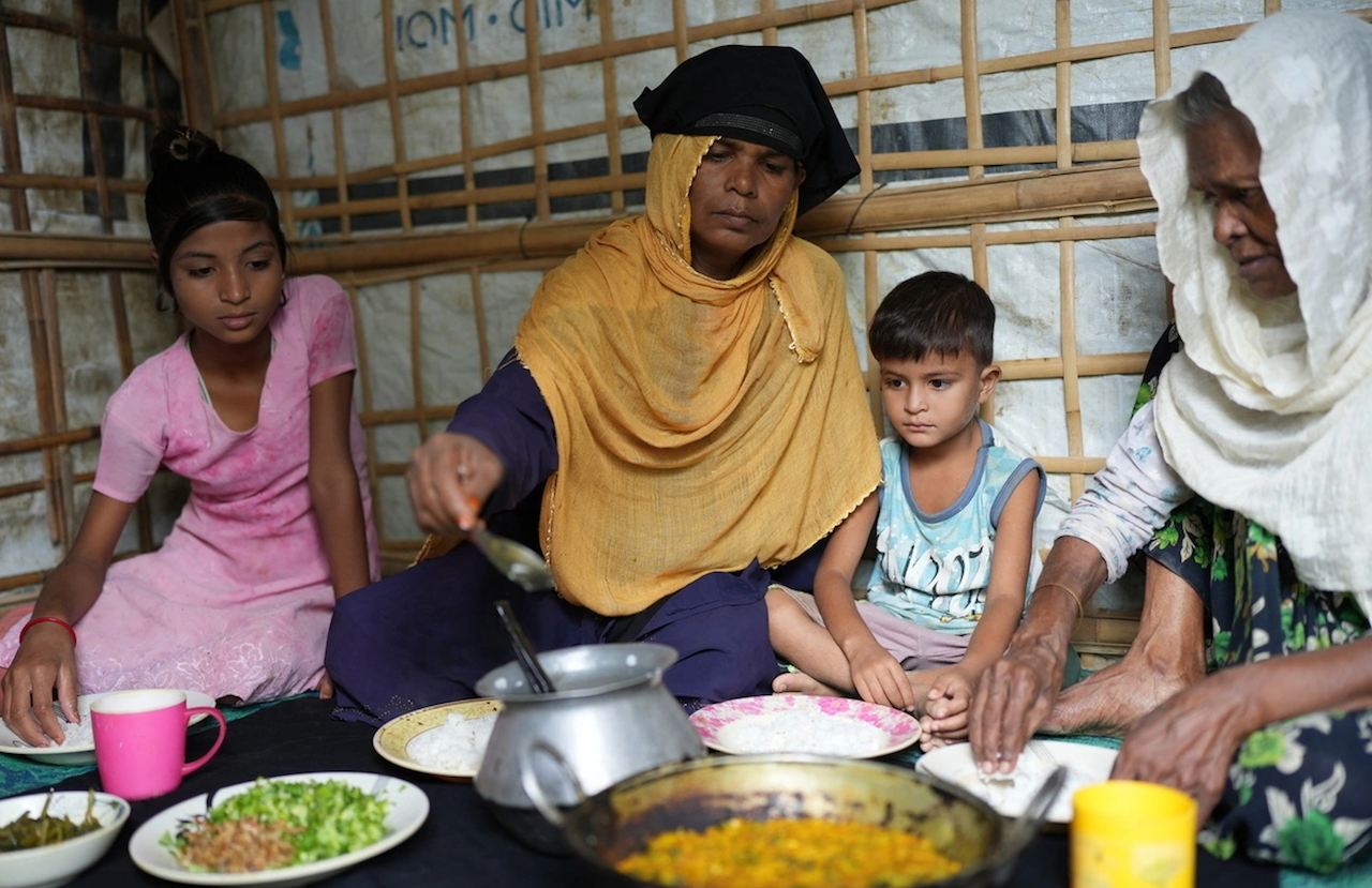 In this photo published by the UN Refugee Agency in July 2023, a Rohingya family shares a meal at a refugee camp in Cox’s Bazar, Bangladesh. (UNHCR)