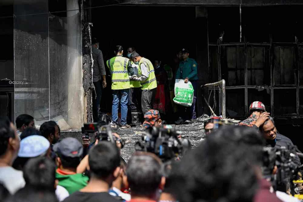 Firefighters and forensic experts inspect the fire site in Dhaka on March 1, 2024. (AFP)
