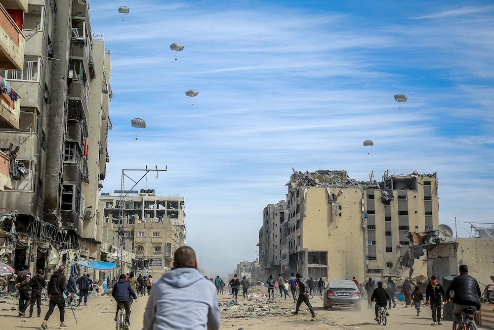 Israel is intentionally starving the population of Gaza and should be held accountable for war crimes and genocide, a UN official earlier said. Above, Palestinians run towards aid that was being air dropped. (AFP)