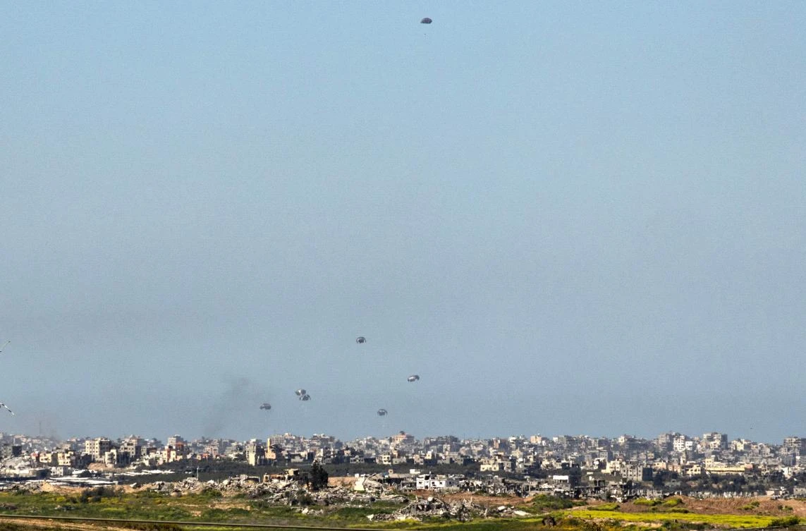 A general view taken from the Israeli side of the border shows aid parcels being airdropped over the northern Gaza Strip on Mar. 5, 2024. (AFP)