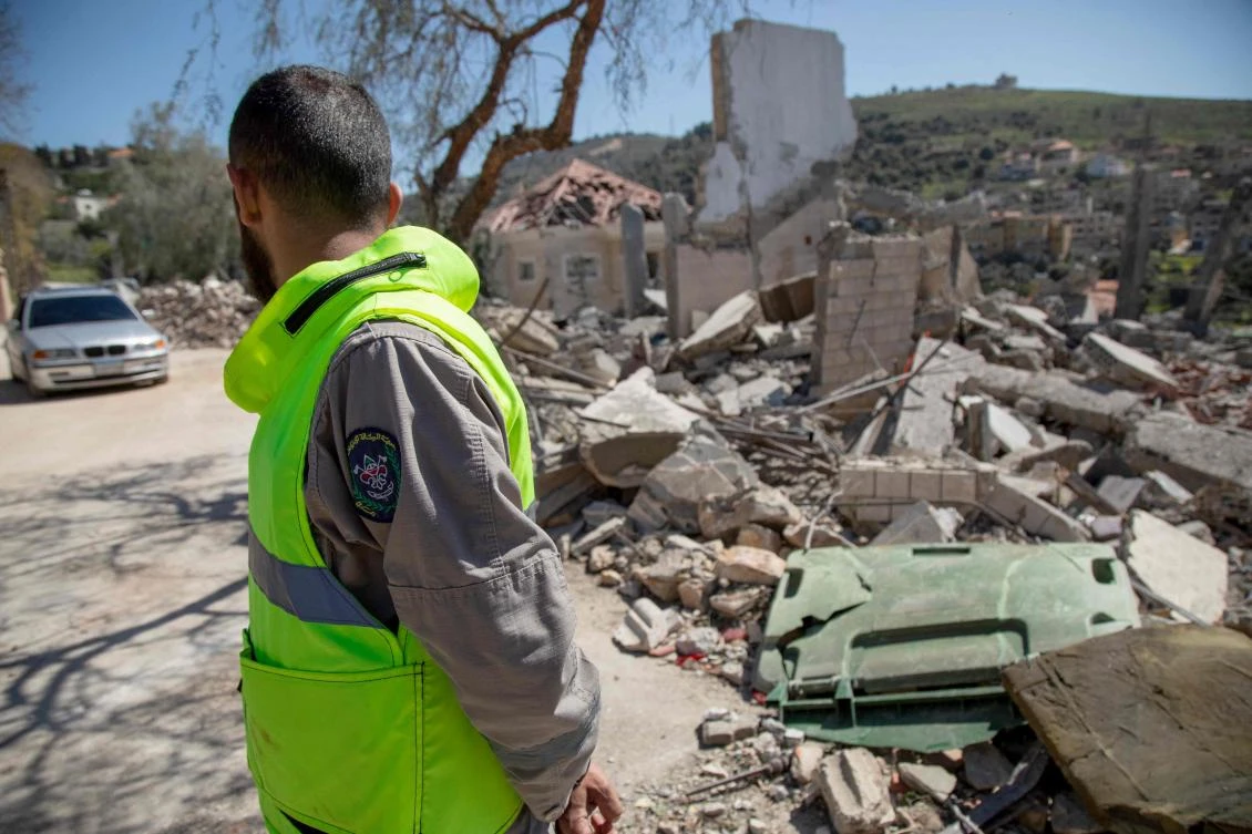 A paramedic looks at the site of an Israeli airstrike a day earlier in the southern Lebanese village of Odaisseh near the border with Israel on Mar. 5, 2024. (AFP)