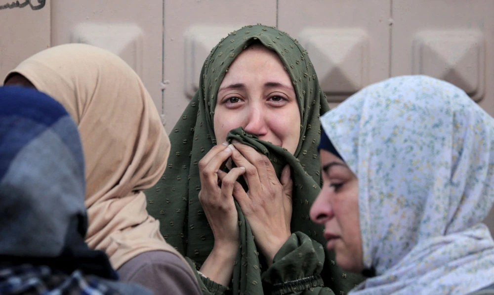 Palestinians mourn at Gaza’s Al-Aqsa Hospital the death of loved ones killed during Israeli bombardment on Wednesday. (AFP)