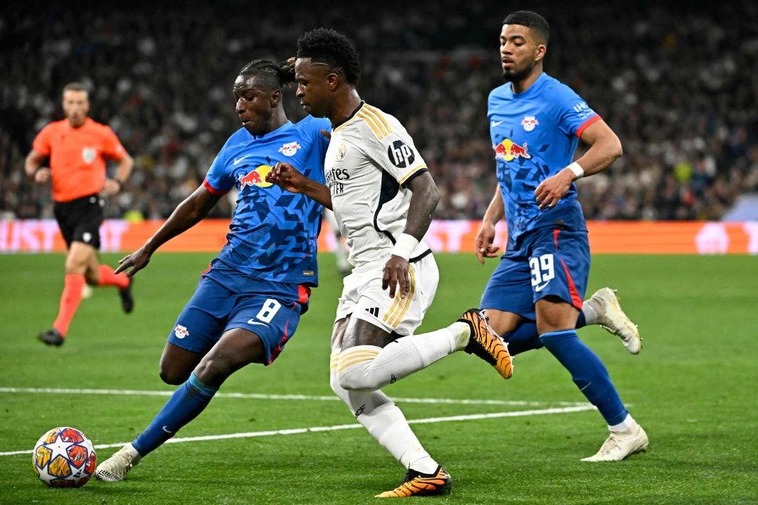 Leipzig's Malian midfielder Amadou Haidara (L) and Real Madrid's Brazilian forward Vinicius Junior vie for the ball during the UEFA Champions League last 16 second leg football match between Real Madrid CF and RB Leipzig at the Santiago Bernabeu stadium in Madrid on March 6, 2024. (AFP)