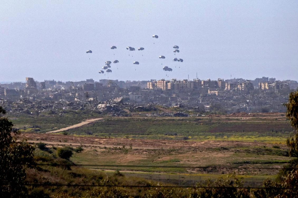 A general view taken from the Israeli side of the border shows aid parcels being airdropped over the northern Gaza Strip on Mar. 5, 2024. (AFP)