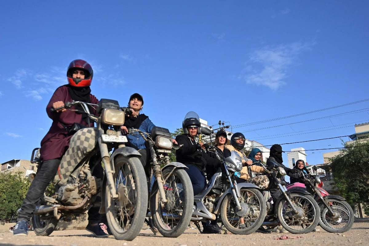 Members and students of the women-only group "Rowdy Riders" line up before riding their bikes during a riding lesson at an open ground in Karachi on March 5, 2024. (AFP)