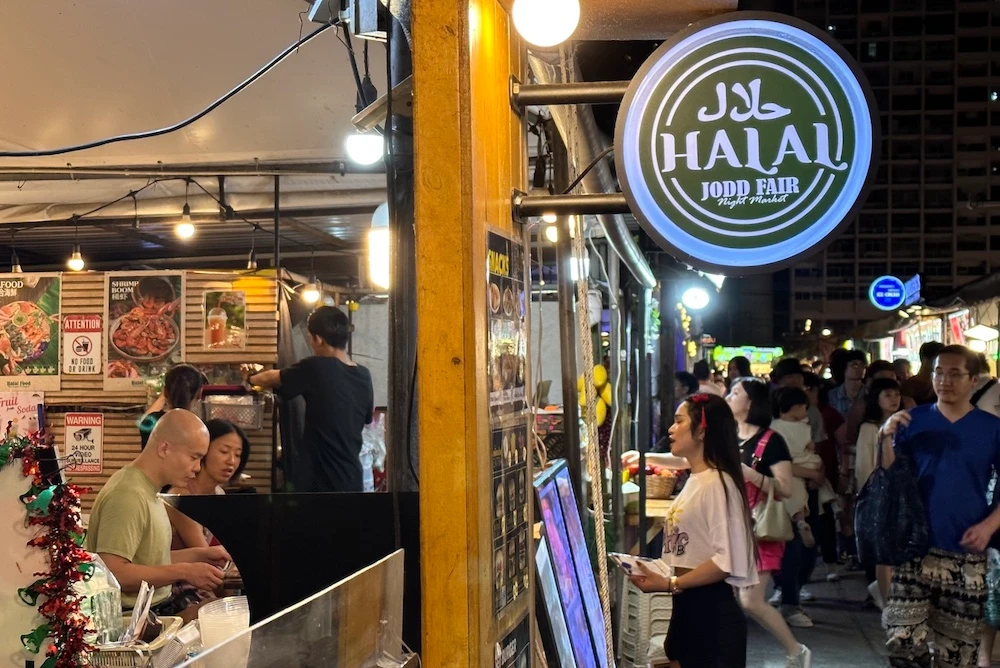 Visitors check the menu of a halal food stall at Jodd Fairs Night Market in Bangkok, Thailand, Feb. 21, 2024. (AN Photo)