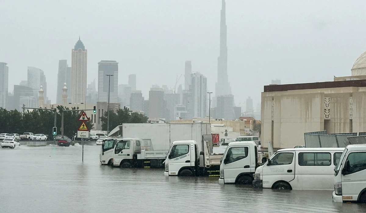 Vehicles stand in floodwaters caused by heavy rains in Dubai on Saturday. Authorities sent crews out to collect downed tree limbs and open drainage grates. (Reuters)